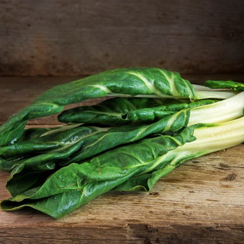 Chard or mangold, raw organic leaf vegetable on a rustic wooden table, copy space, selected focus